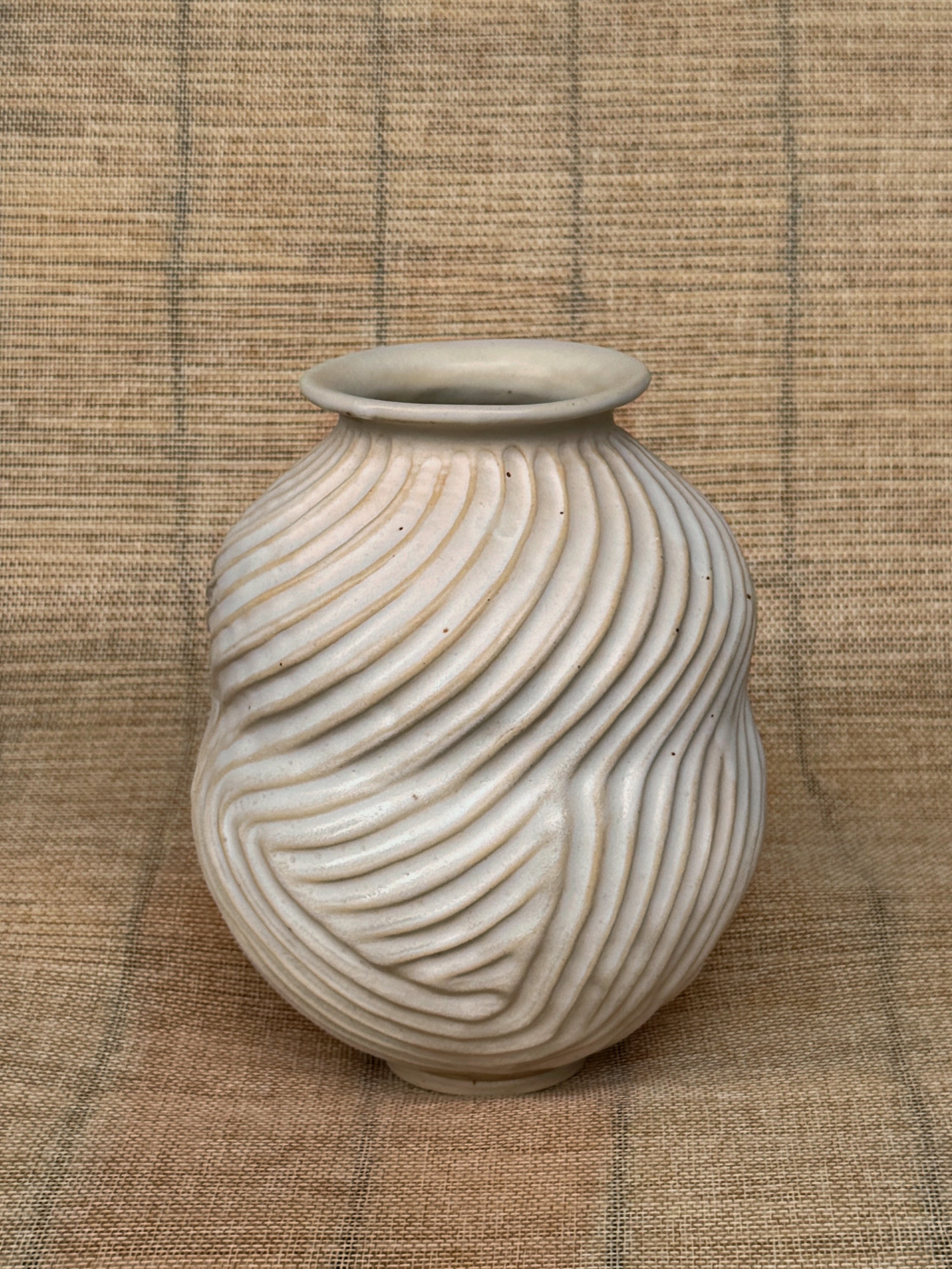 Rounded stoneware vase carved in diagonal waves with matte cream glaze, Honeycomb collection